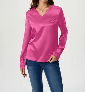 Detail view of an elegant hot pink long sleeve satin blouse with V-neck on a female model