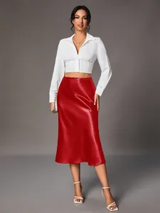 Elegant high-waisted red satin midi skirt styled with a white cropped button-up shirt.