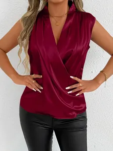 Detail of maroon satin sleeveless blouse featuring a wrap V-neck and shiny texture.