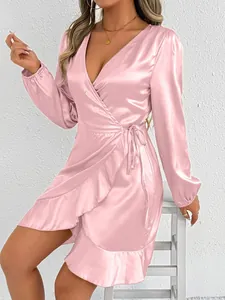 Detailed view of elegant pink satin wrap dress with long sleeves and ruffled hemline