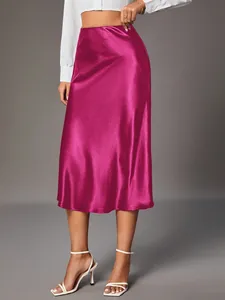Detailed shot of fuchsia satin midi skirt showing elegant shine and flowy fabric