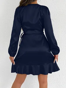 Close-up back view of a navy blue satin long-sleeved dress with elegant ruffled hemline