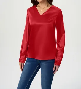 Detailed view of a red long-sleeved satin blouse with a V-neck and button cuffs.