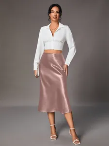 Rose gold satin midi skirt paired with a white cropped shirt on a fashion model in studio