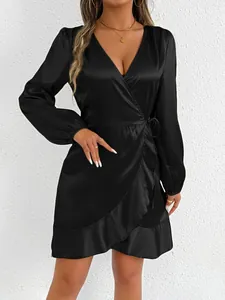 Close-up of elegant black satin long sleeve wrap mini dress featuring a ruffle hem
