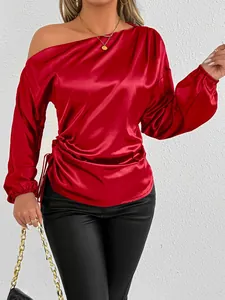 Close-up of red satin off-the-shoulder long sleeve blouse with gathered side detail