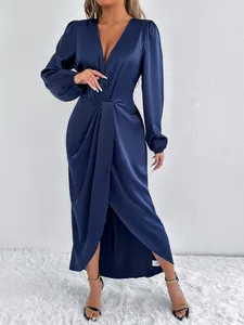 Detailansicht eines eleganten, langärmeligen Wickelkleids aus marineblauem Satin mit V-Ausschnitt