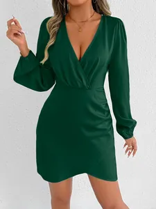 Close-up of elegant dark green satin mini dress featuring a V-neck and gathered wrap design