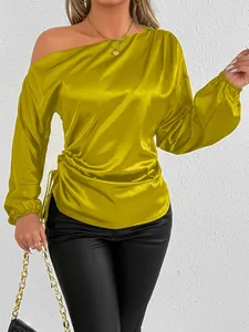 Close-up of yellow satin off-shoulder long sleeve top with ruched side detail