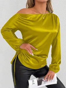 Detailed macro shot of mustard yellow satin off-shoulder long sleeve blouse with side drawstring