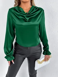Detailed view of an elegant dark green satin blouse with cowl neck and ruffled cuffs