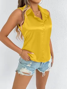 Detalle que muestra el ajuste y la textura satinada de una blusa amarilla sin mangas