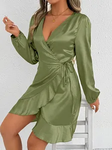 Detail of an elegant olive green satin wrap dress with long sleeves and ruffled hem.