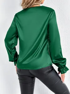 Back view of emerald green satin long sleeve blouse with ruffled cuffs and glossy finish