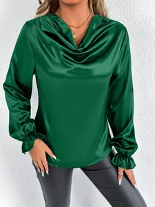 Detail of elegant emerald green satin blouse featuring a draped cowl neck and ruffled cuffs