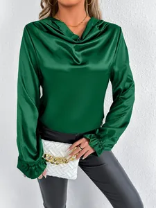 Detailed view of the dark green satin blouse featuring a cowl neck and ruffled cuffs.