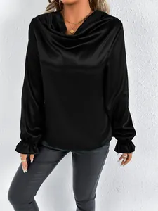 Close-up of elegant black satin cowl neck blouse with ruffled cuffs for women