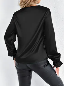 Back view of elegant black satin blouse with silky texture and ruffled cuffs