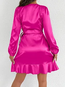Back view of a vibrant fuchsia satin long sleeve dress with ruffle hem and waist tie