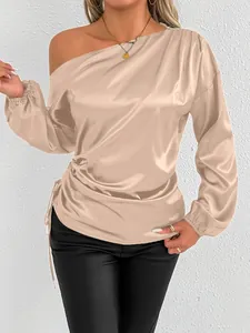Close-up of champagne satin one-shoulder long sleeve blouse with side drawstring