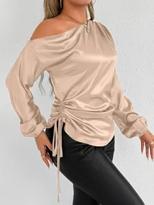 Close-up of champagne satin long-sleeve blouse with side drawstring and off-shoulder neckline
