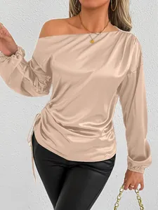 Detailed close-up view of elegant champagne satin off-shoulder blouse with side drawstring
