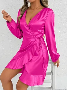 Detail of a fuchsia satin wrap dress with long sleeves and elegant ruffle hemline.