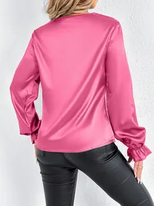 Back view of an elegant pink satin blouse featuring smooth fabric and ruffled cuff details
