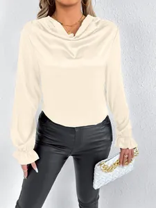 Elegant cream satin blouse detail featuring a cowl neck and ruffled cuffs on model