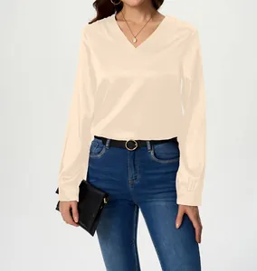 Close-up of elegant cream satin V-neck blouse showing the silky texture and long sleeves