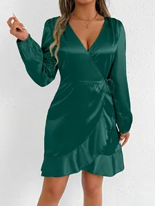 Detailed view of an emerald green satin long sleeve wrap dress featuring elegant ruffle hem