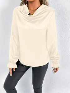 Detail of cream satin blouse with elegant cowl neck and ruffled long sleeve cuffs