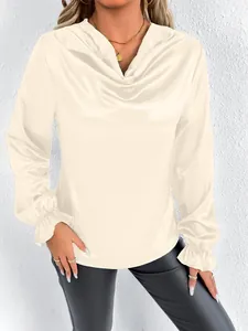 Detailed macro view of cream satin blouse with elegant cowl neck and ruffled sleeve cuffs
