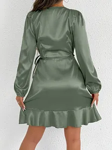 Detailed back view of an elegant sage green satin long-sleeve dress with ruffle hem detail