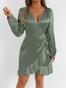 Detail of sage green satin long sleeve wrap dress with ruffle hem and V-neckline.