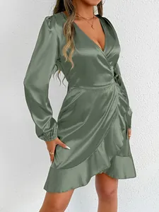 Close-up showing the lustrous sage green satin fabric and ruffle detail of a wrap dress