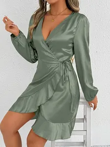 Close-up detail of an elegant sage green satin wrap dress featuring ruffled hemline