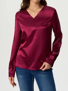 Elegant wine red long-sleeved satin blouse with V-neck worn by model on plain background