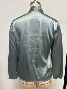 Vue arrière détaillée d'un chemisier en satin vert brillant sur un mannequin de couture