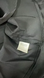 Close-up of black satin dress fabric showing 90% Polyester 10% Elastane care label