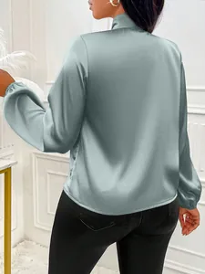Vue arrière d'un élégant chemisier en satin vert sauge avec col montant et détail de nœud