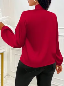 Vue arrière du chemisier en satin rouge élégant avec manches bouffantes et col noué