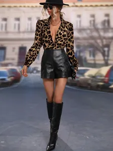 Detailed view of women's leopard print satin shirt paired with black leather shorts