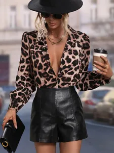 Detailed shot of leopard print satin blouse paired with chic black leather shorts.