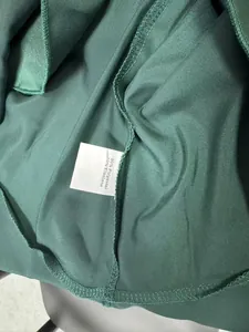 Close-up detail of the fabric composition label for a dark green polyester dress