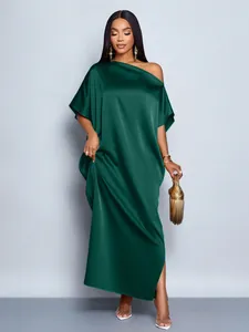 Detail view of a dark green satin one-shoulder maxi dress with a side slit