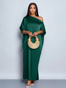 Elegant emerald green satin dress featuring off-shoulder detail and gold handbag