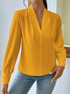 Detail view of a vibrant yellow satin long-sleeve blouse with a stylish V-neck design.