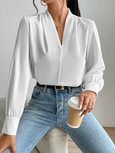 Detailed view of elegant white satin V-neck blouse with soft pleat texture.