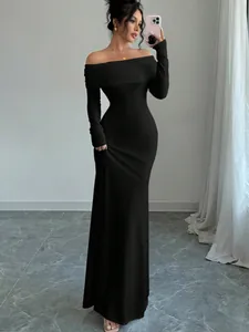 Elegante abito lungo nero aderente con spalle scoperte e maniche lunghe per eventi serali